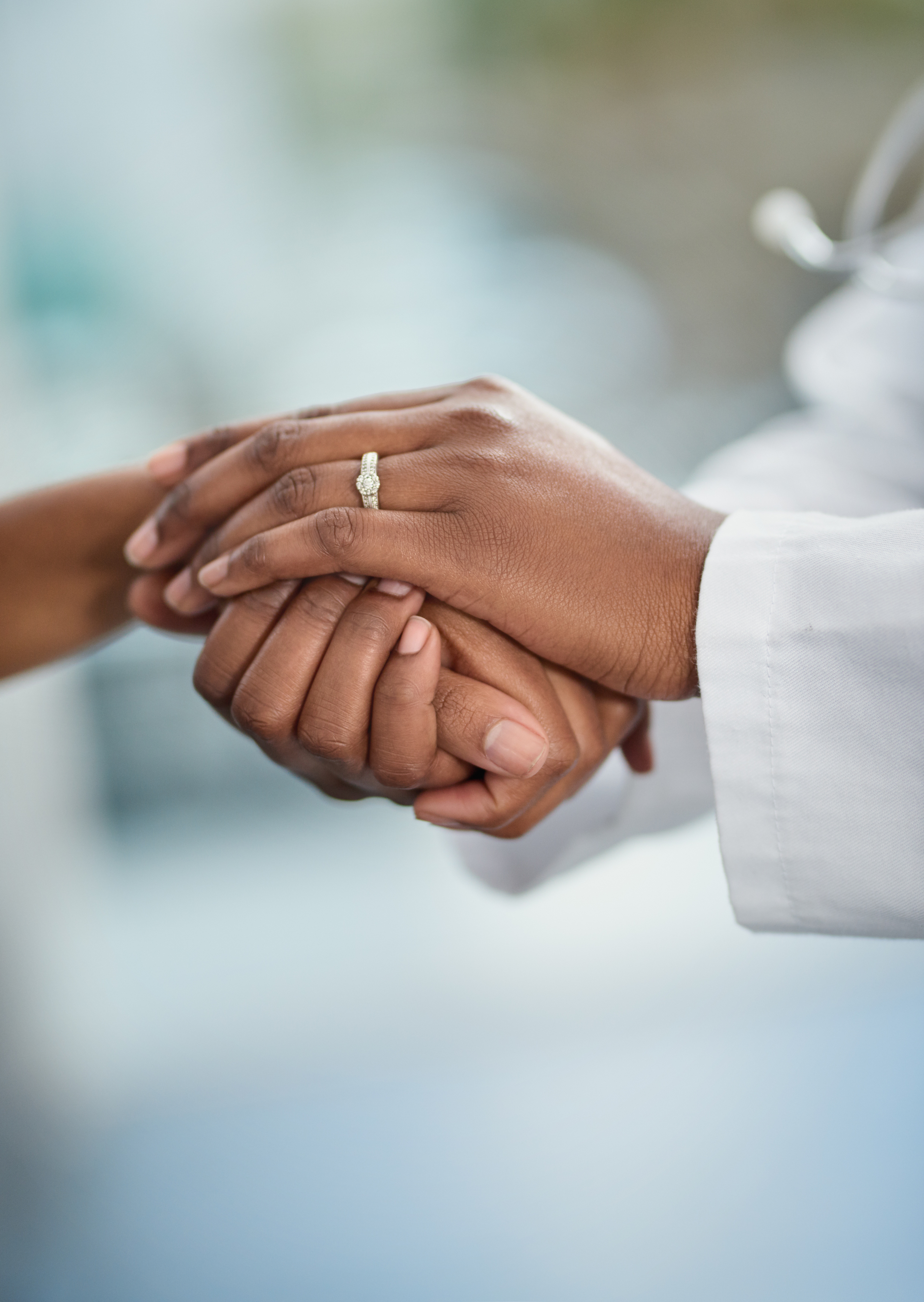 Closeup shot of a doctor holding a patient's hand in comfort